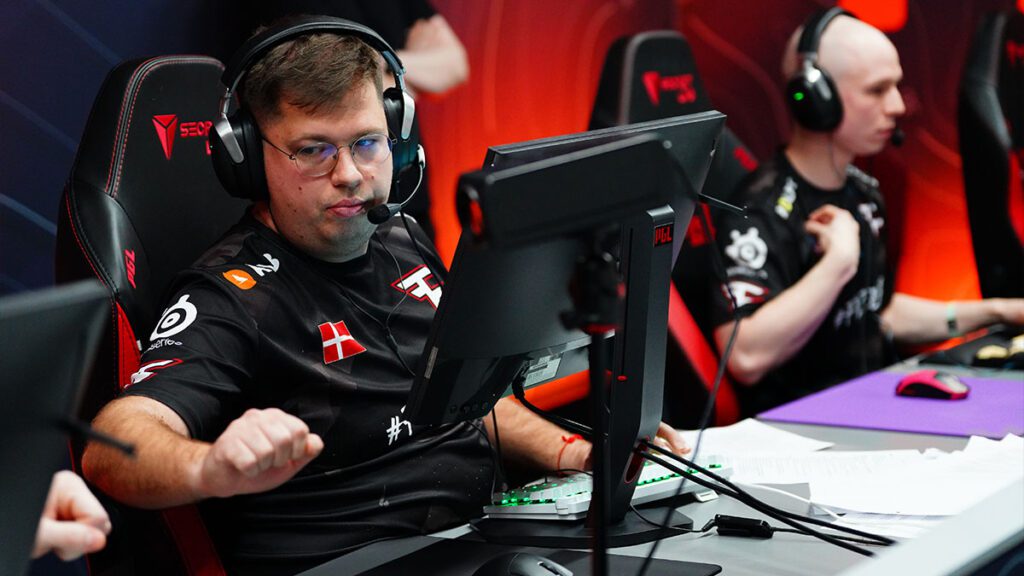 Esports players from FaZe Clan focused during a Counter-Strike match, sitting at gaming PCs with headsets.