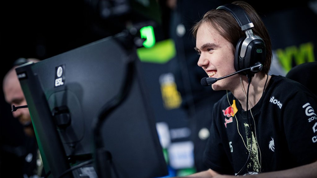 Esports player intently focusing on a Counter-Strike match during an ESL tournament, wearing a headset and team jersey