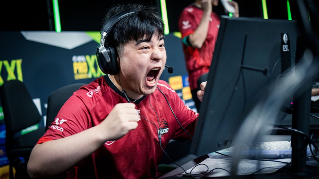 Excited esports player wearing a headset celebrates during a Counter-Strike tournament