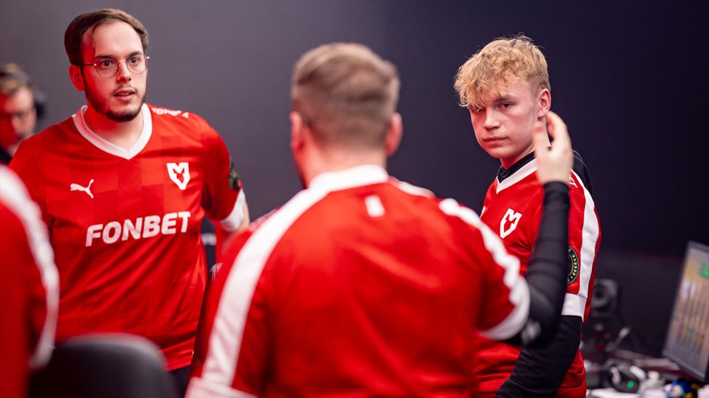 Esports team in red jerseys having a discussion in a gaming setup