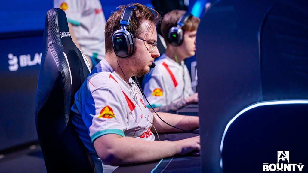 Esports players focused during a competitive Counter-Strike match, wearing headphones and team jerseys.