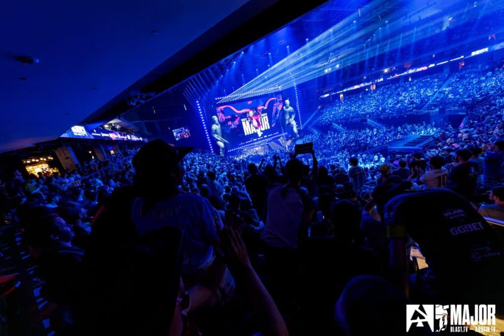 Massive crowd attending a Counter-Strike esports tournament, vibrant stage lighting, and large screen displaying tournament branding.