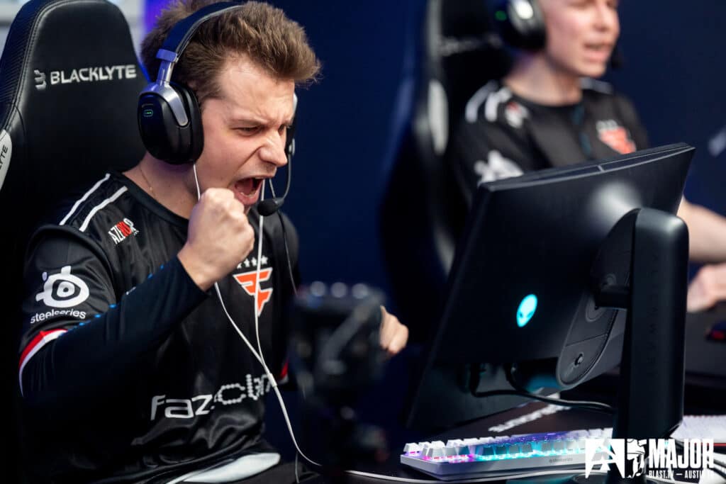 Esports player celebrating victory during a Counter-Strike match at a gaming event.