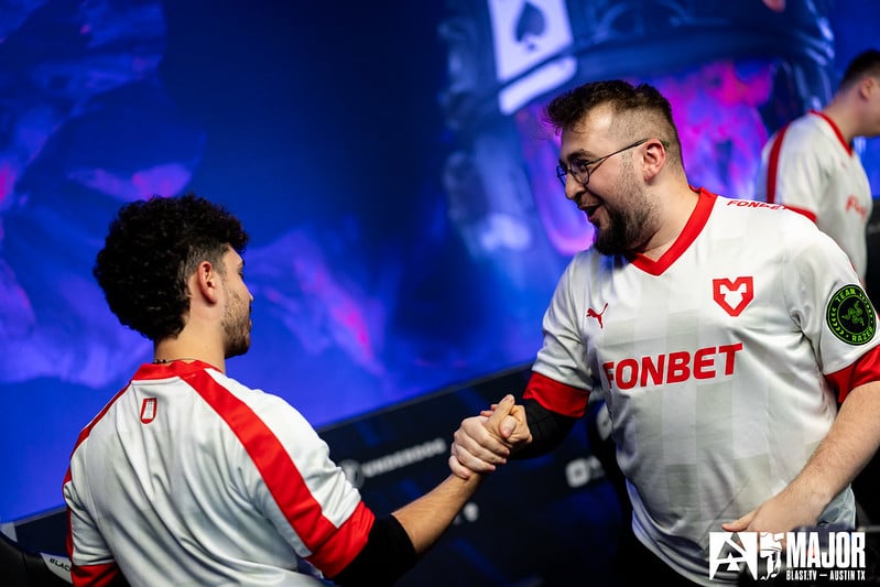 Two esports players in team jerseys celebrating during a Counter-Strike tournament