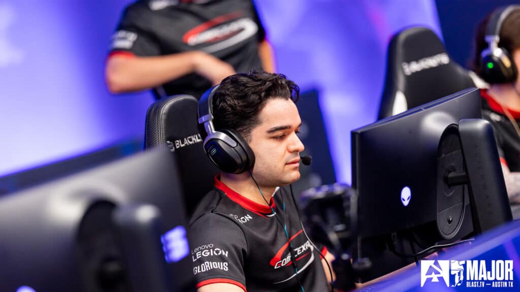 Esports player focused on a Counter-Strike match at a gaming event with the BLAST Premier logo in the background.