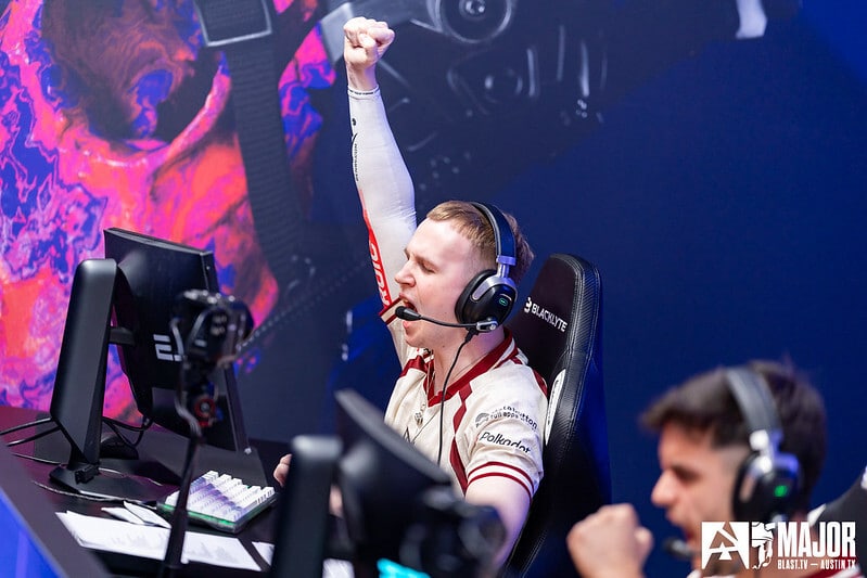 Esports player celebrating a victory during a Counter-Strike match at a gaming event