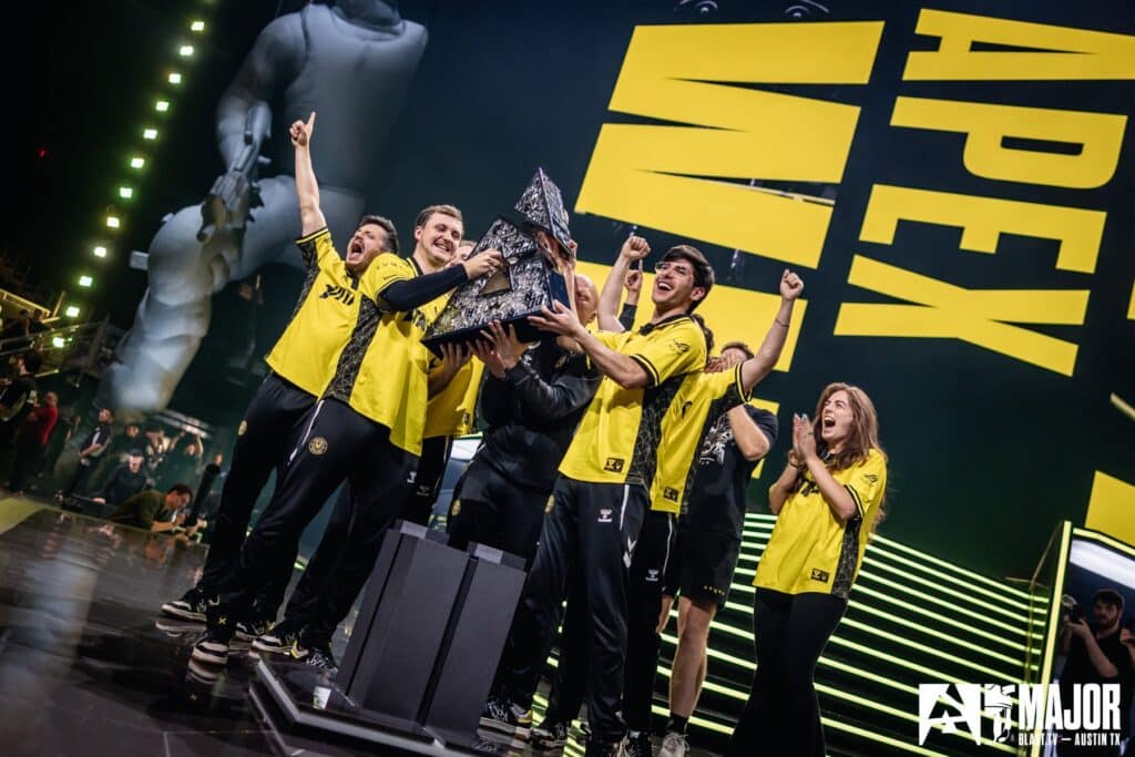 Esports team celebrating victory on stage at Major tournament
