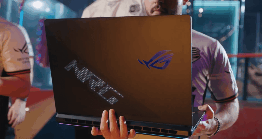 Esports player holding ASUS ROG laptop with NRG logo at gaming event