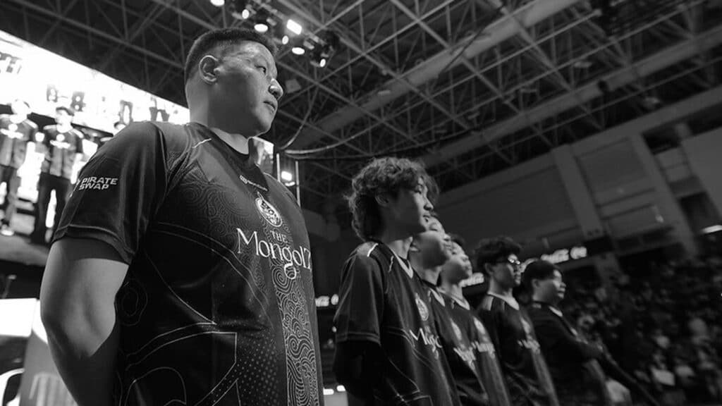 Esports team in matching jerseys stands on stage at a competitive gaming event