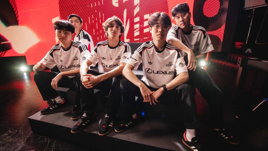 Esports team posing on stage with vibrant red backdrop