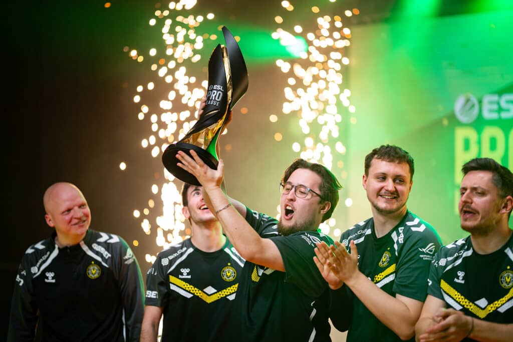 Esports team celebrating victory with trophy at ESL Pro League event, sparks flying