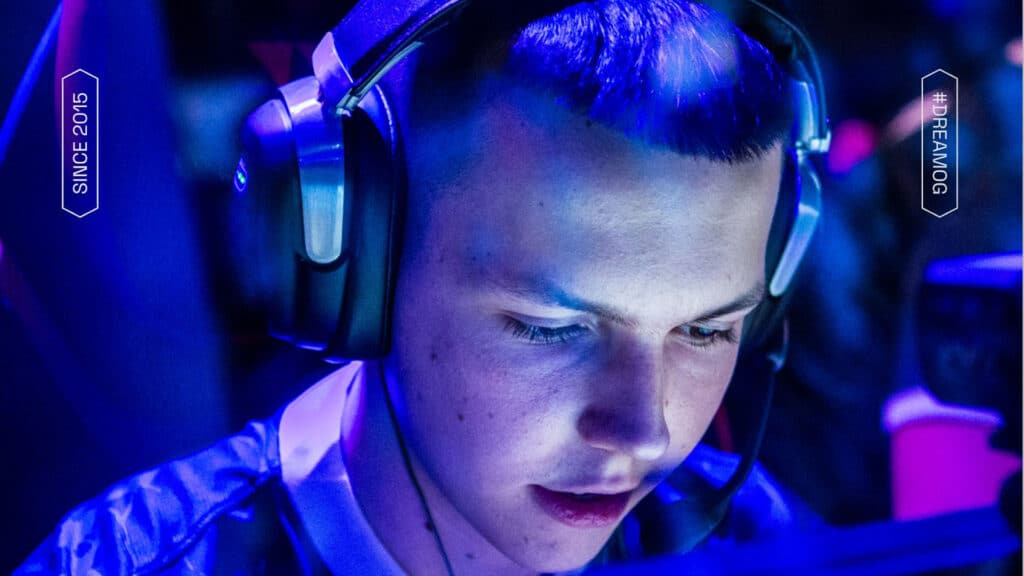 Focused gamer wearing headphones in an esports event with blue lighting