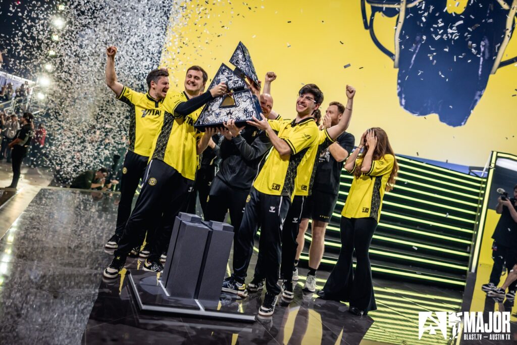 Esports team celebrating victory on stage with trophy at BLAST Major event