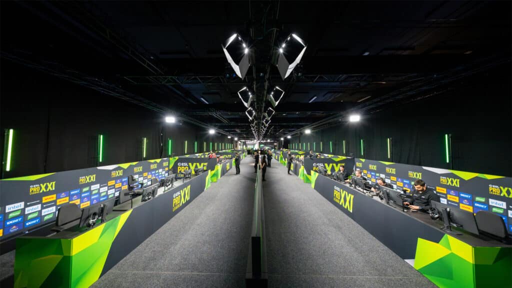 Professional esports players compete in a Counter-Strike tournament with green and black themed setups at ESL Pro League XXI.