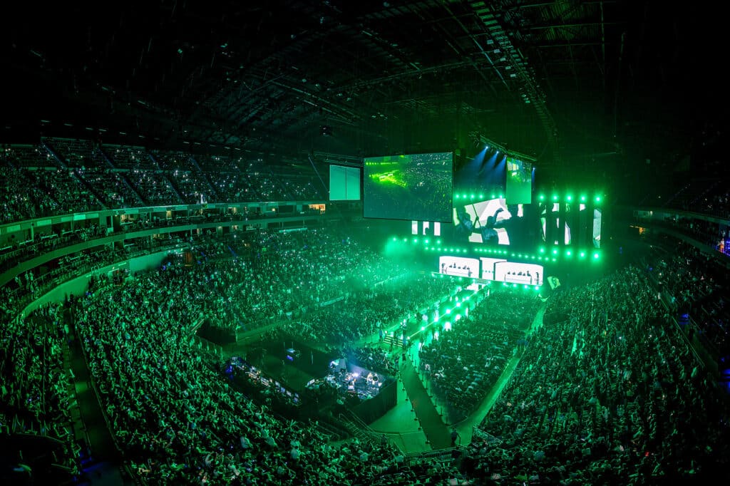 Packed esports arena with vibrant green lighting for a Counter-Strike tournament