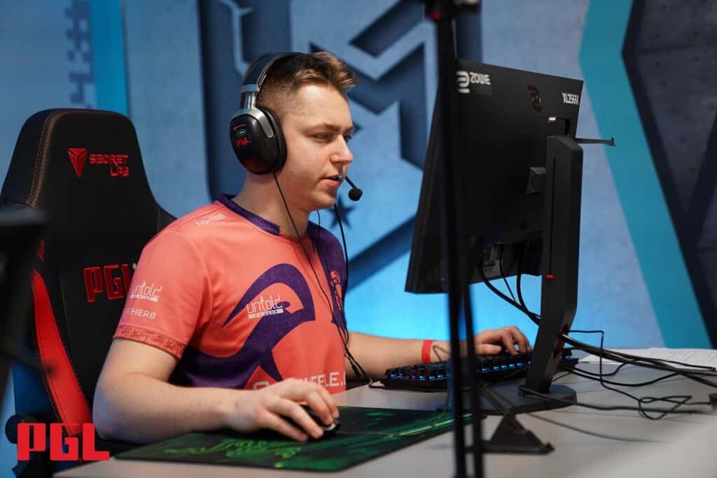 Esports player focused on computer screen during a PGL Counter-Strike tournament.