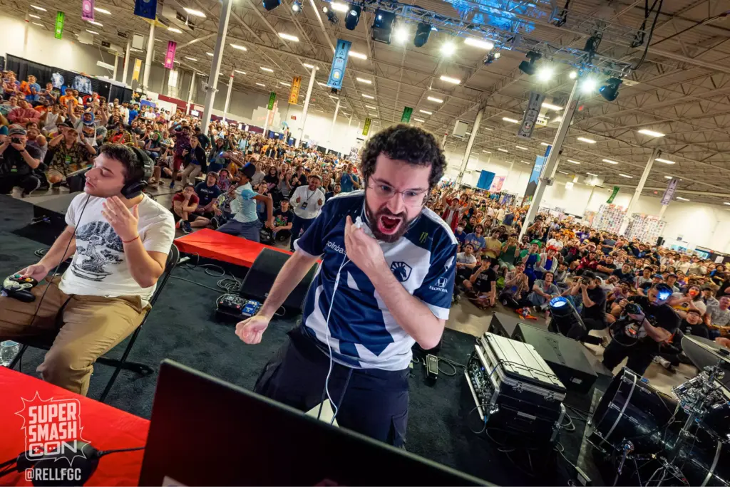 Esports players in an intense gaming match at Super Smash Con with a cheering crowd